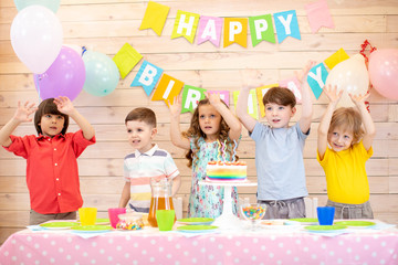 Obraz na płótnie Canvas happy children at table celebrating birthday holiday