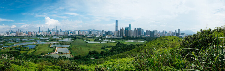 Panorama view of rural green fields with fish ponds between Hong Kong and skylines of Shenzhen,China