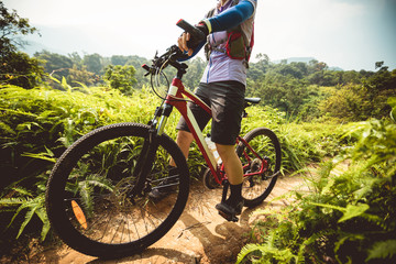 Fototapeta na wymiar Cross country biking woman cyclist riding mountain bike on tropical rainforest trail