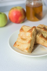 pieces of Apple pie on a white plate with honey.