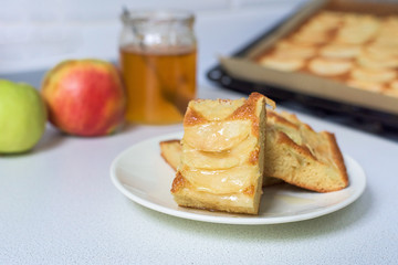 Apple pie on a white plate with honey.