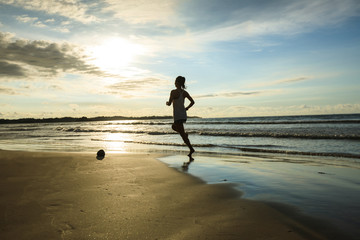 Naklejka premium Fitness woman runner running on sunrise beach