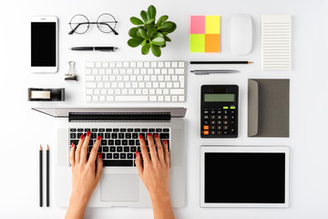 Woman’s hands working on laptop. Modern office desktop concept. Top view