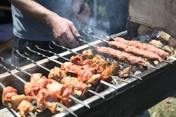 Appetizing shashlik is preparing on the open air.