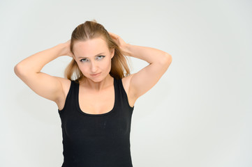 Studio waist-length photo portrait of a pretty beautiful young happy blonde woman on a white background in a black t-shirt. Smiling, talking, showing emotions.