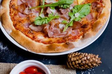close up parma ham pizza with pine cones