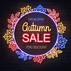 Neon sign autumn big sale with maple leaves on brick background. Vintage electric signboard.