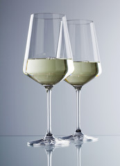 zwei Gläser Weisswein isoliert auf grauem Untergrund