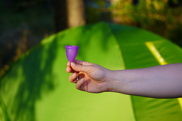 reusable Menstrual Cup on vacation, camping, during outdoor activities. convenience, environmental friendliness, zero waste. modern female purity. concept of tourism and travel.