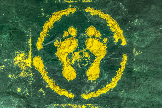 Traditional Rangoli Art of Indian culture. This Goddess Foot Marks are made at the entrance on auspicious occasions of Hindu Festival. The design is made of yellow powder (Gulaal) on Green Background