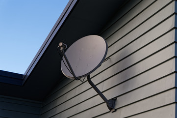 A satellite dish on the side of a building