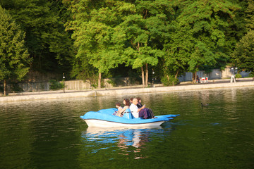 Fototapeta na wymiar Family rides a blue catamaran on a lake in the mountains 