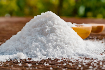 Slide salt on an old wooden table with a wooden spoon, close-up
