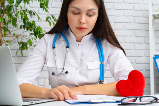 Brunette female doctor working at her table in hospital close up