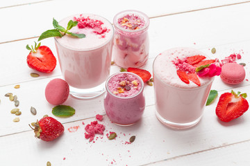 Strawberry with yogurt on white rustic wooden background. Cream dessert