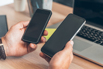 Man using mobile smart phone. Business man hands using cell phone at office desk.