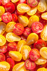 Fresh halves of Mexican cherry tomatoes. Sliced yellow and red cherry tomatoes.Background of many colorful cherry tomatoes. Cherry tomatoes top view.