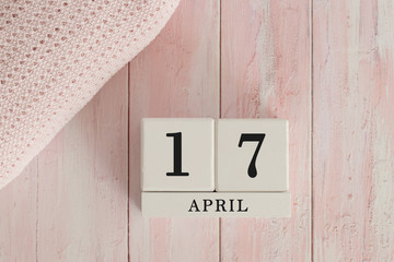 17 April Date on Cubes. Date on painted pink wood, next to baby blanket. Theme of baby due dates...
