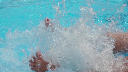 Girls sitting on the edge of a pool dangling feets in the water.