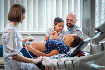 Obraz premium Pregnant woman and her family on utltrasonographic examination at hospital