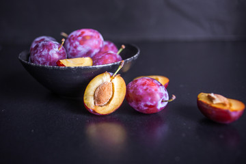 Delicious juicy blue plums in a bowl on the table,
