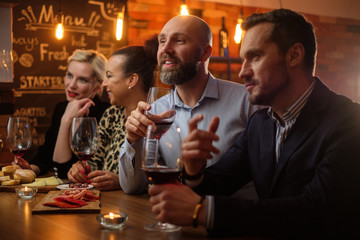 Group of friends having fun talk behind bar counter in a cafe