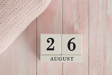 26 August Date on Cubes. Date on painted pink wood, next to baby blanket. Theme of baby due dates and birth dates.