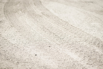 Fototapeta na wymiar Tire tread footprints of a tractor on the sand.