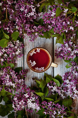 cup of tea with lilac on the wooden table