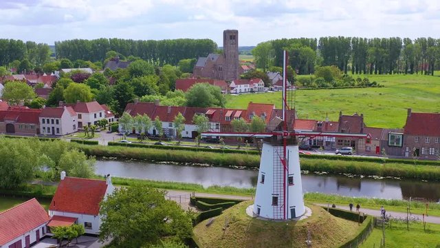 Aerial over canal and small town of Damme, Belgium and historic windmill.