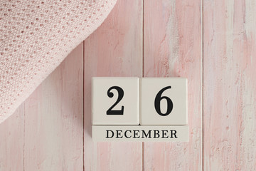 26 December Date on Cubes. Date on painted pink wood, next to baby blanket. Theme of baby due dates and birth dates.