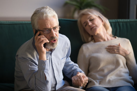 Elder husband calling 911 on phone for wife heart attack