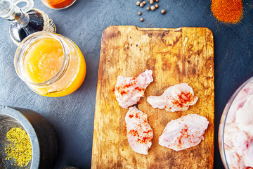 Raw chicken wings with spices on a wooden cutting board