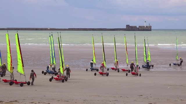 Land carts or sail carts or blokarts are wheeled onto the beach in France.