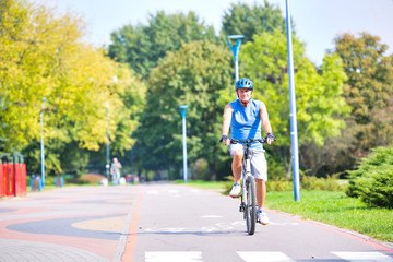 Senior male athlete riding bicycle in park