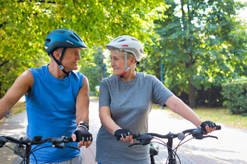 Fit senior couple with bicycles looking at each other