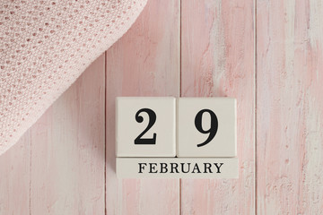 29 February Date on Cubes. Date on painted pink wood, next to baby blanket. Theme of baby due dates...