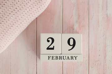 29 February Date on Cubes. Date on painted pink wood, next to baby blanket. Theme of baby due dates and birth dates.