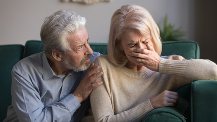 Worried kind senior husband comforting crying mature wife giving compassion