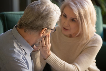 Loving mature wife comforting gently touching face of elder man