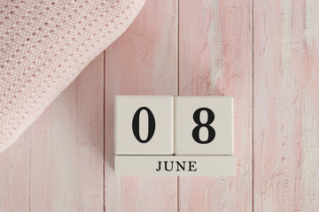 8 June Date on Cubes. Date on painted pink wood, next to baby blanket. Theme of baby due dates and birth dates.