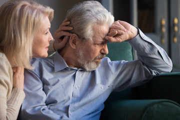 Loving worried middle aged wife comforting apologizing sad senior husband