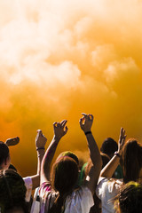Group of people dancing in front of holi powder explosion