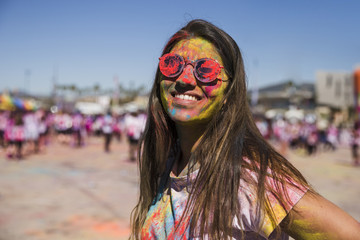 Holi color on woman's face looking at camera