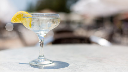 Glass cup with alcohol a slice of lemon and ice. Wine glass with an alcoholic cocktail and lemon.