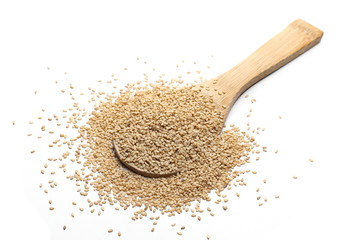 Organic integral sesame seeds with wooden spoon isolated on white background