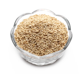 Organic integral sesame seeds in glass bowl isolated on white background