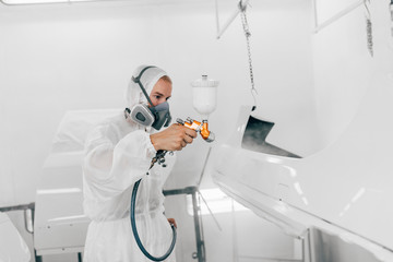 Painting car parts in a paint chamber.