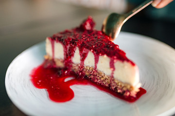 Eating delicious cheesecake with a spoon, close-up.