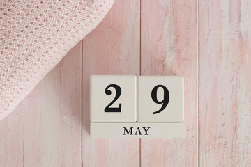 29 May Date on Cubes. Date on painted pink wood, next to baby blanket. Theme of baby due dates and birth dates.